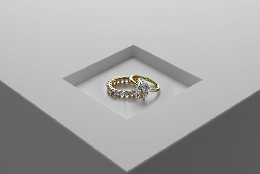 A close-up of exquisite gold and diamond rings set on a minimalist surface.