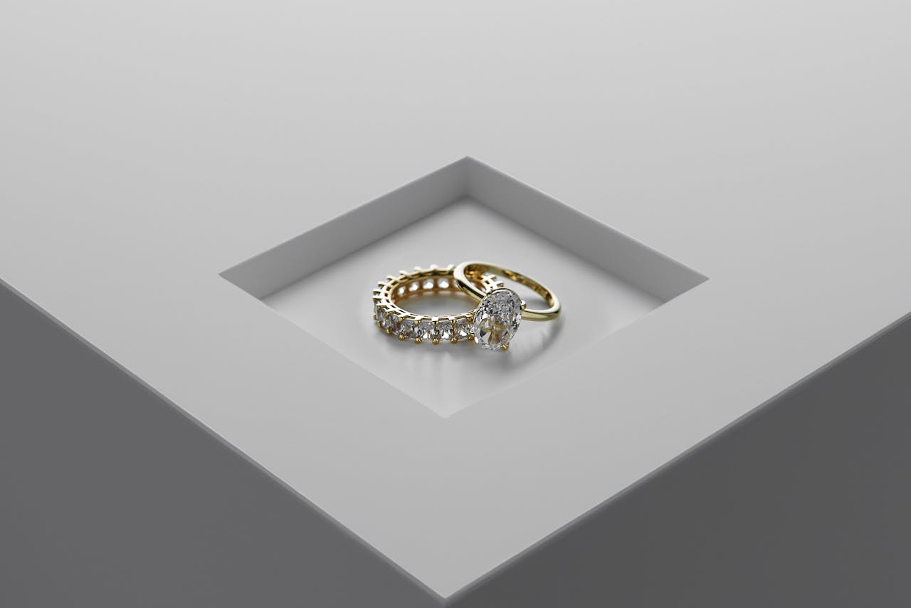 A close-up of exquisite gold and diamond rings set on a minimalist surface.